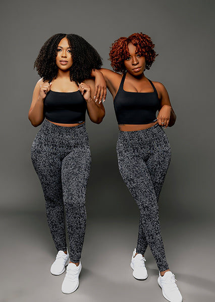 fit black women posing for a woman-owned black owned business wearing unique black activewear sets that feature seamless scrunch butt high waist leggings and open back sports bra